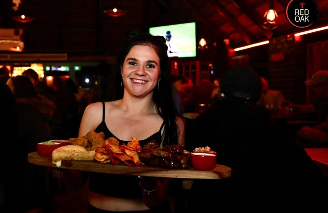 A server carrying a loaded platter through the bar.