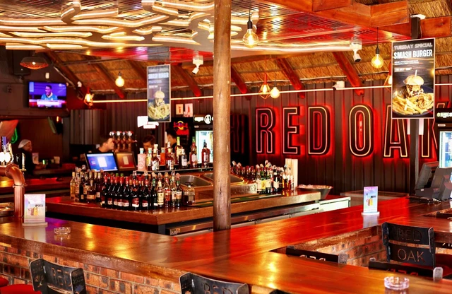 The full Red Oak bar with the red RED OAK sign above the spirits shelf.