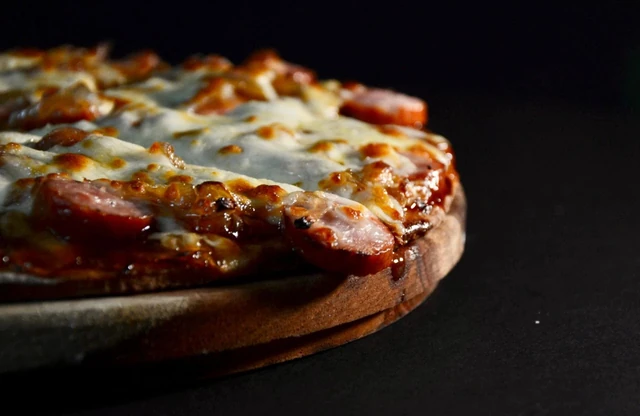 A Red Oak pizza fresh from the oven on a wooden board.