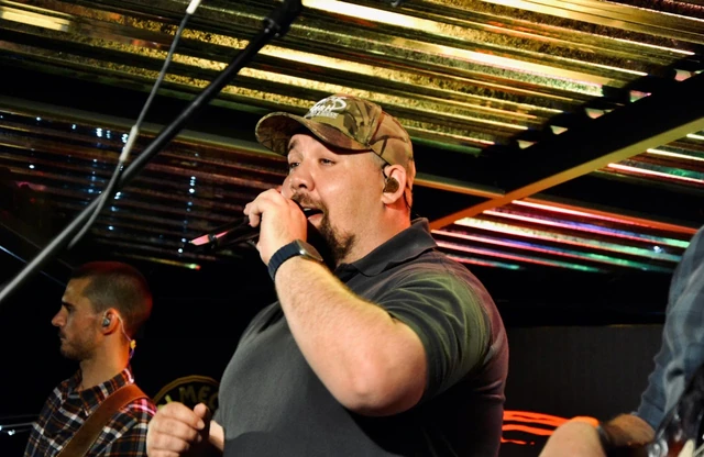 A singer performing under the warm light strips.