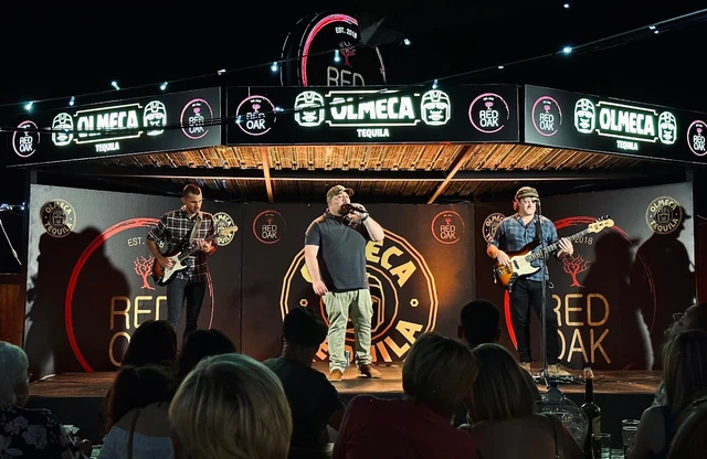 A live band performing on the Olmeca and Red Oak branded stage.