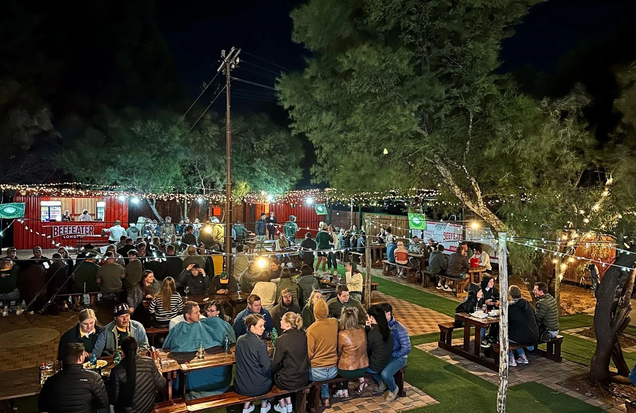 The Red Oak outdoor area at night, strung with warm lights and full of guests.