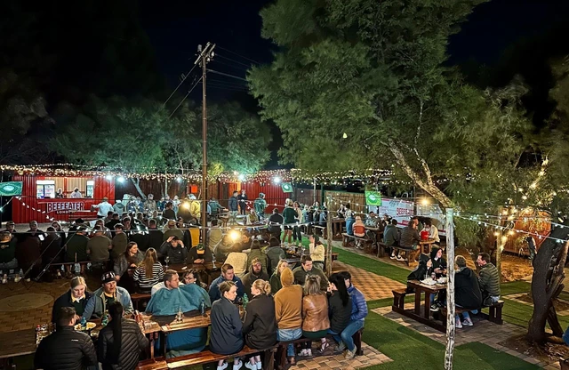The Red Oak outdoor area at night, strung with warm lights and full of guests.