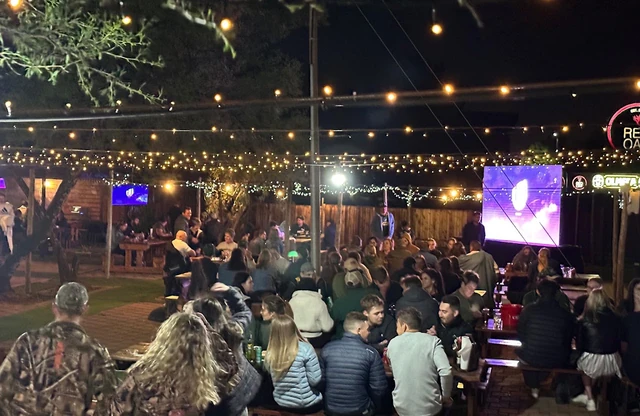 The outdoor area under strings of lights during an evening event.