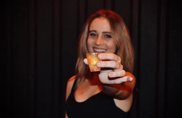 A guest raising a cocktail towards the camera.