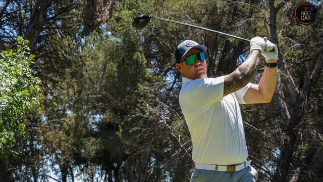 A golfer following through on a tee shot at the Red Oak Golf Day.
